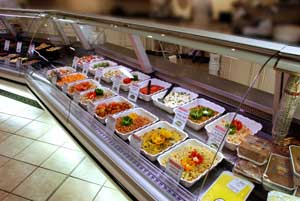 Ensaladas delicatessen en gabinetes refrigerados de supermercados